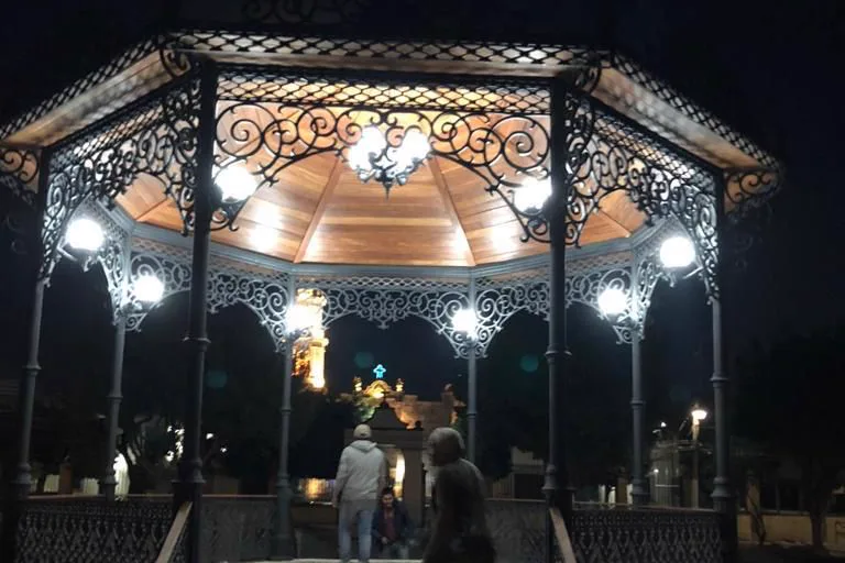 Kiosco Guadalajara de noche: friso de herrería calada y techo interior de madera